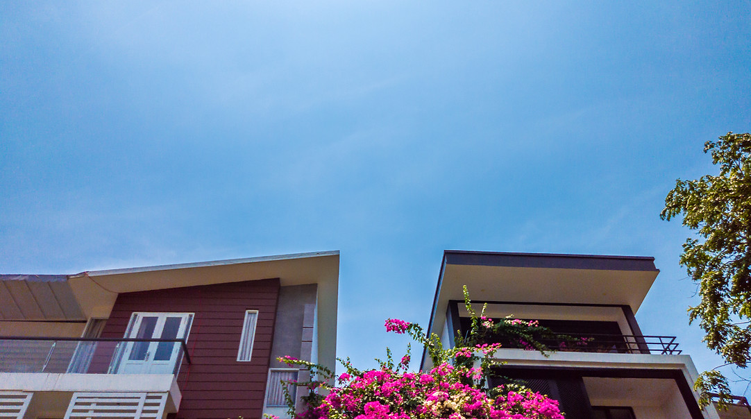 roof-house-with-nice-window-blue-sky-bright-green-trees-flowers-near.jpg