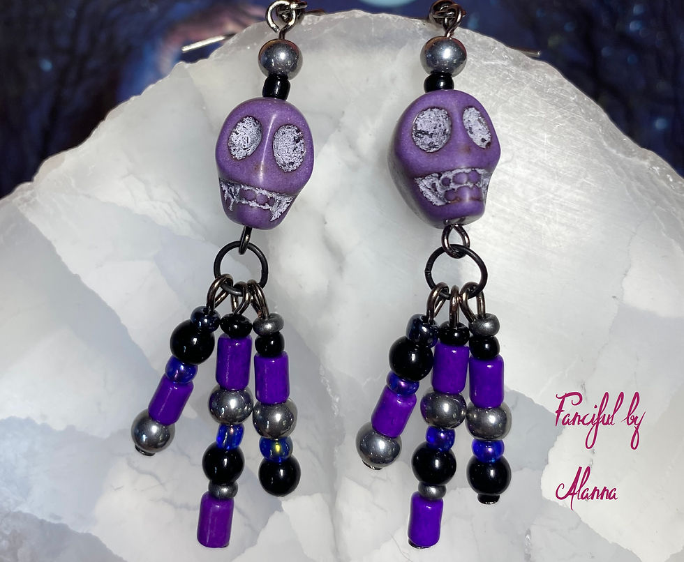 Thumbnail: Purple Día de los Muertos skull earrings with black, gold, and purple wood and glass beads closeup
