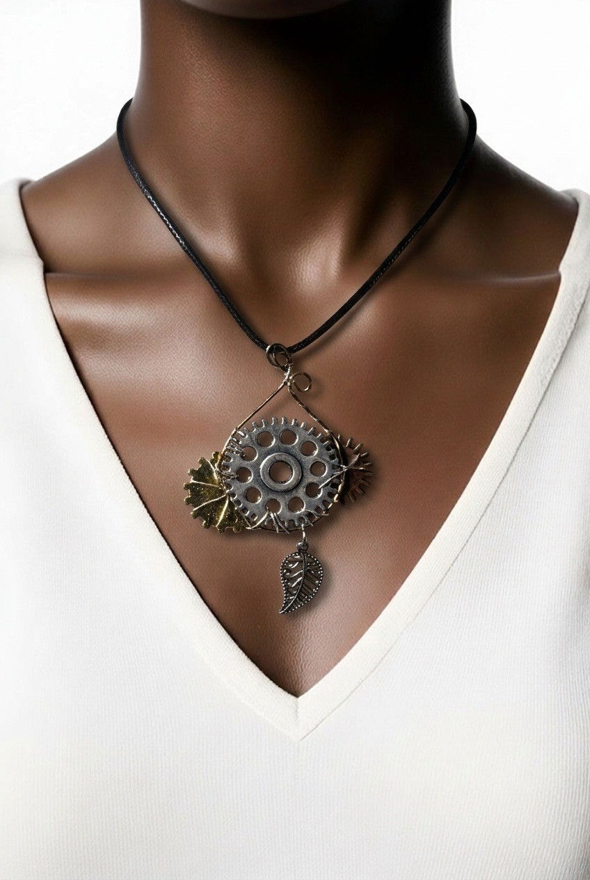 Handmade steampunk necklace featuring a large silver gear accented with copper and gold tone gears and silver leaf on model