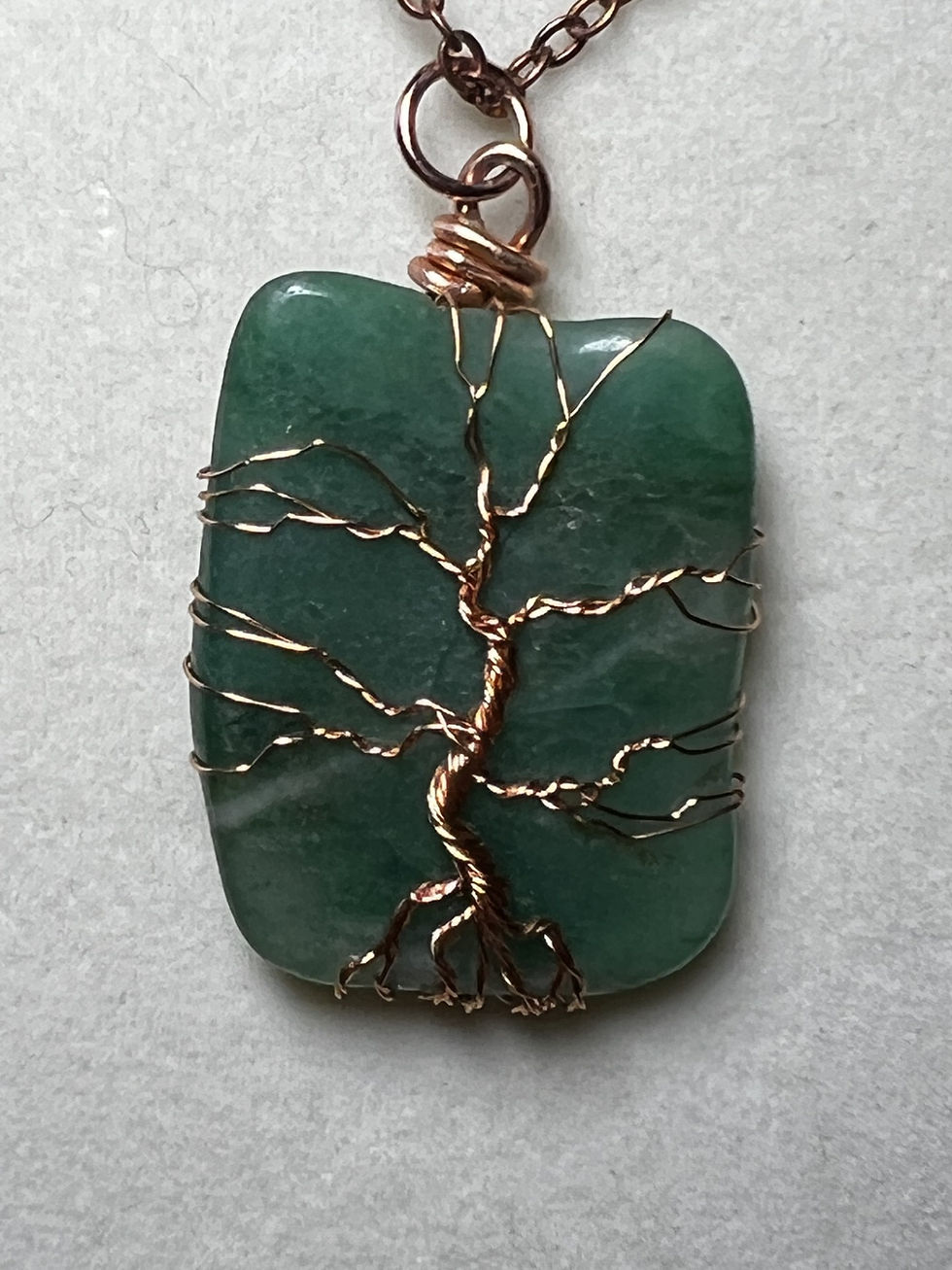 Thumbnail: Handmade green agate pendant featuring an intricate copper wire Tree of Life design close up