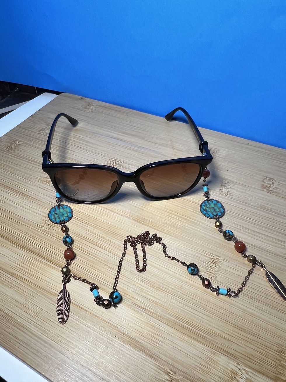 Thumbnail: Handmade copper eyeglass chain with turquoise and carnelian beads, feather charms, and hammered copper accents on table
