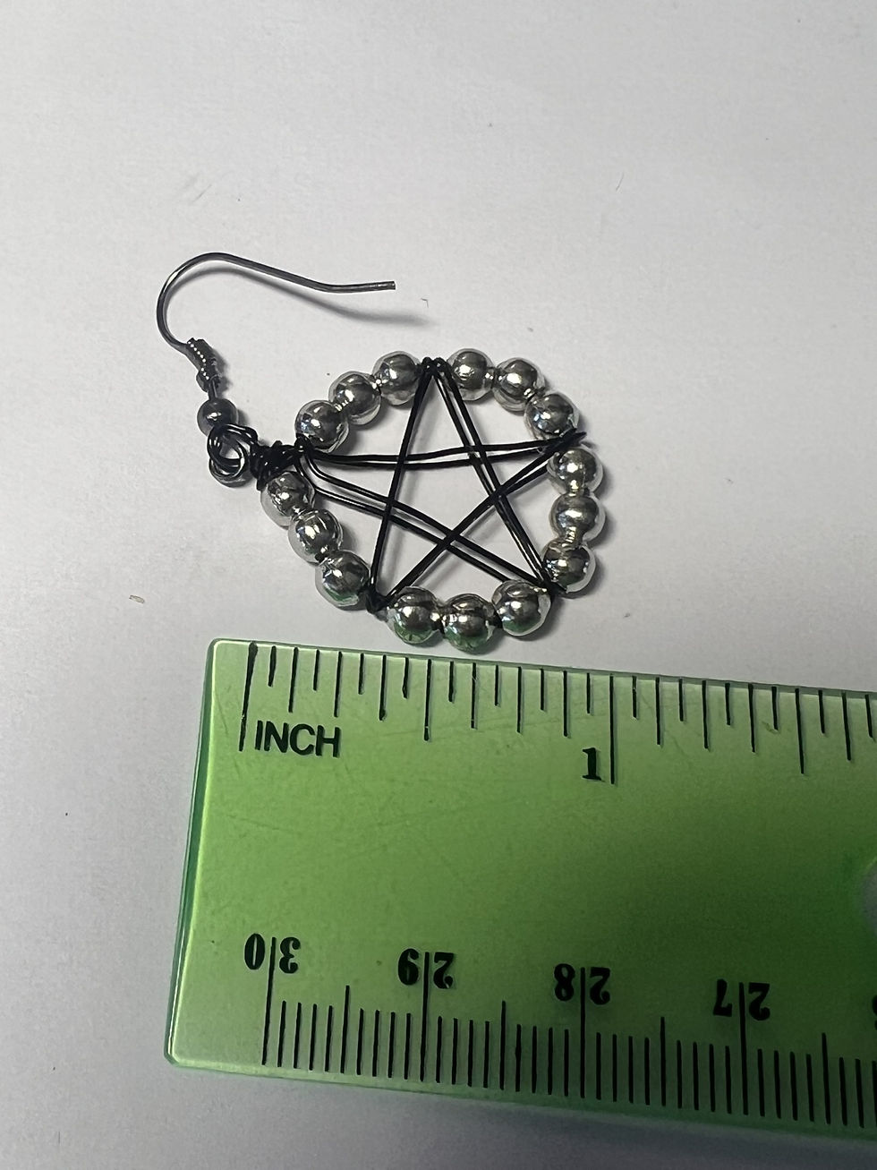 Thumbnail: Handmade black wire wrapped pentacle earrings with silver bead accents hanging from silver ear wires measure