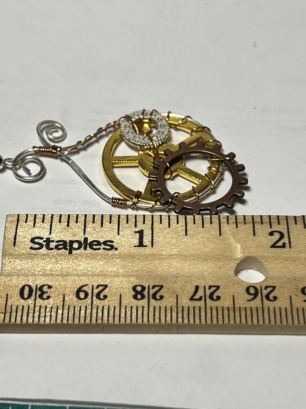 Thumbnail: Handmade wire wrapped steampunk earrings featuring a large gold gear surrounded by a silver wire frame length