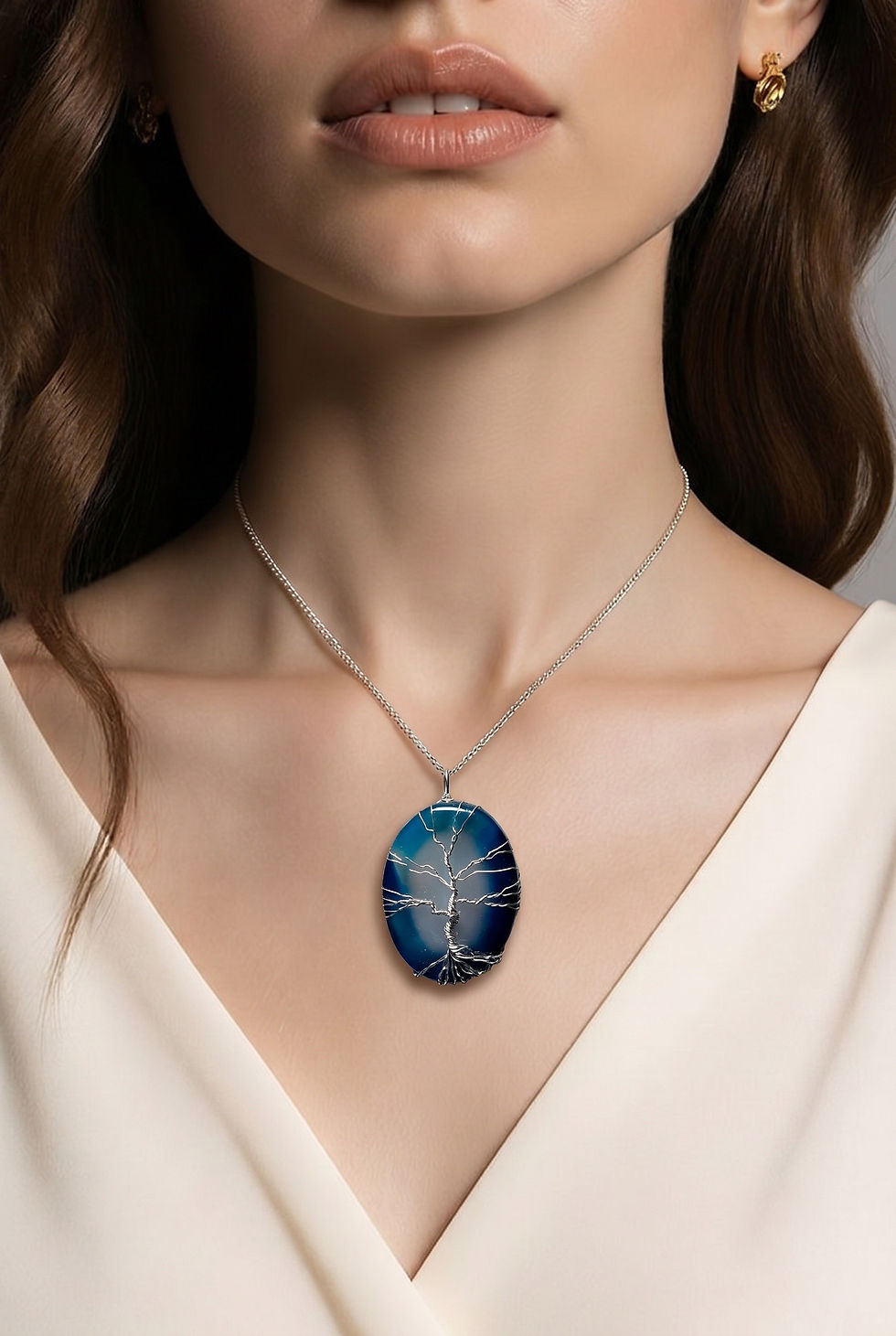 Handmade blue agate slice pendant featuring a silver wire Tree of Life design on model