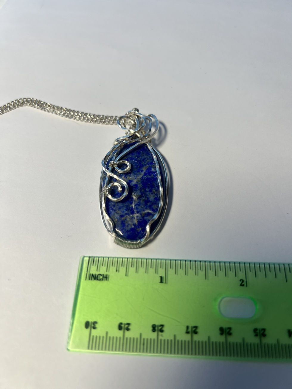 Thumbnail: Handmade lapis lazuli pendant wrapped in twisted and curved silver wire with deep blue natural gemstone tones measure