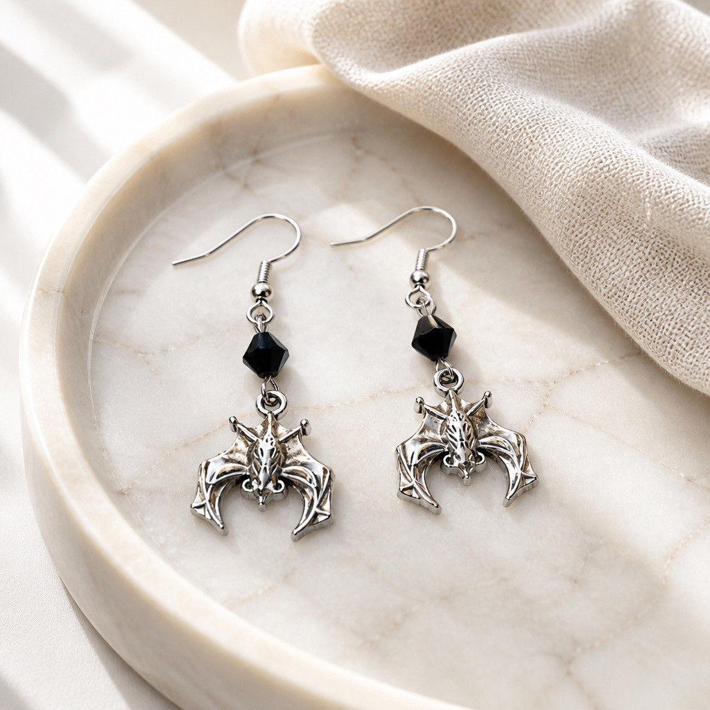 Handmade small bat charm earrings suspended from red or black faceted bicone beads