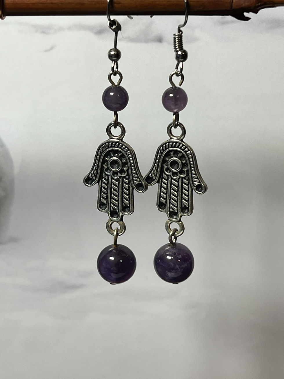 Thumbnail: Silver Hamsa hand dangle earrings with purple amethyst beads in two sizes closeup