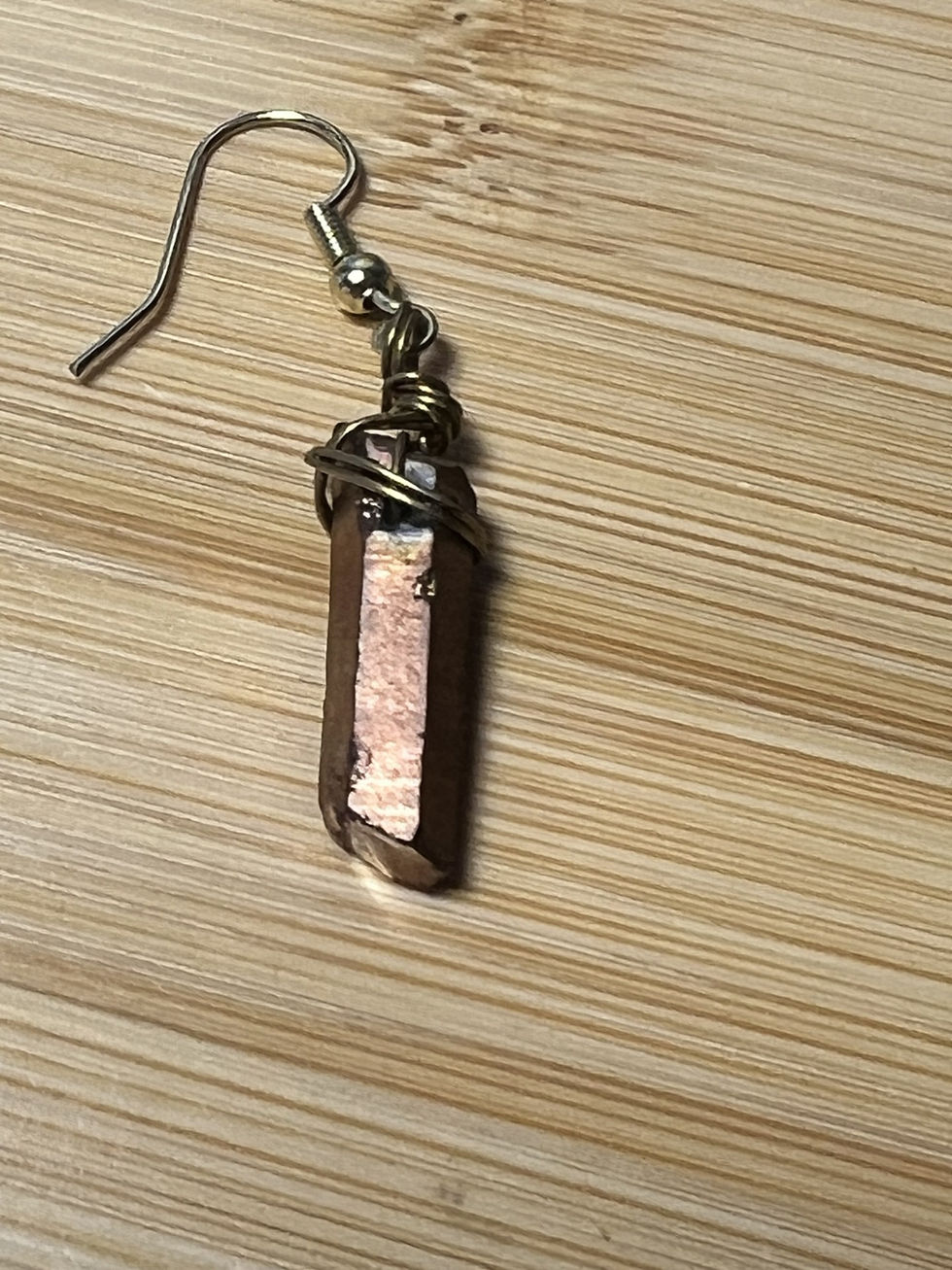 Thumbnail: Handmade bronze quartz crystal earrings wrapped in gold wire with a simple bohemian style.closeup