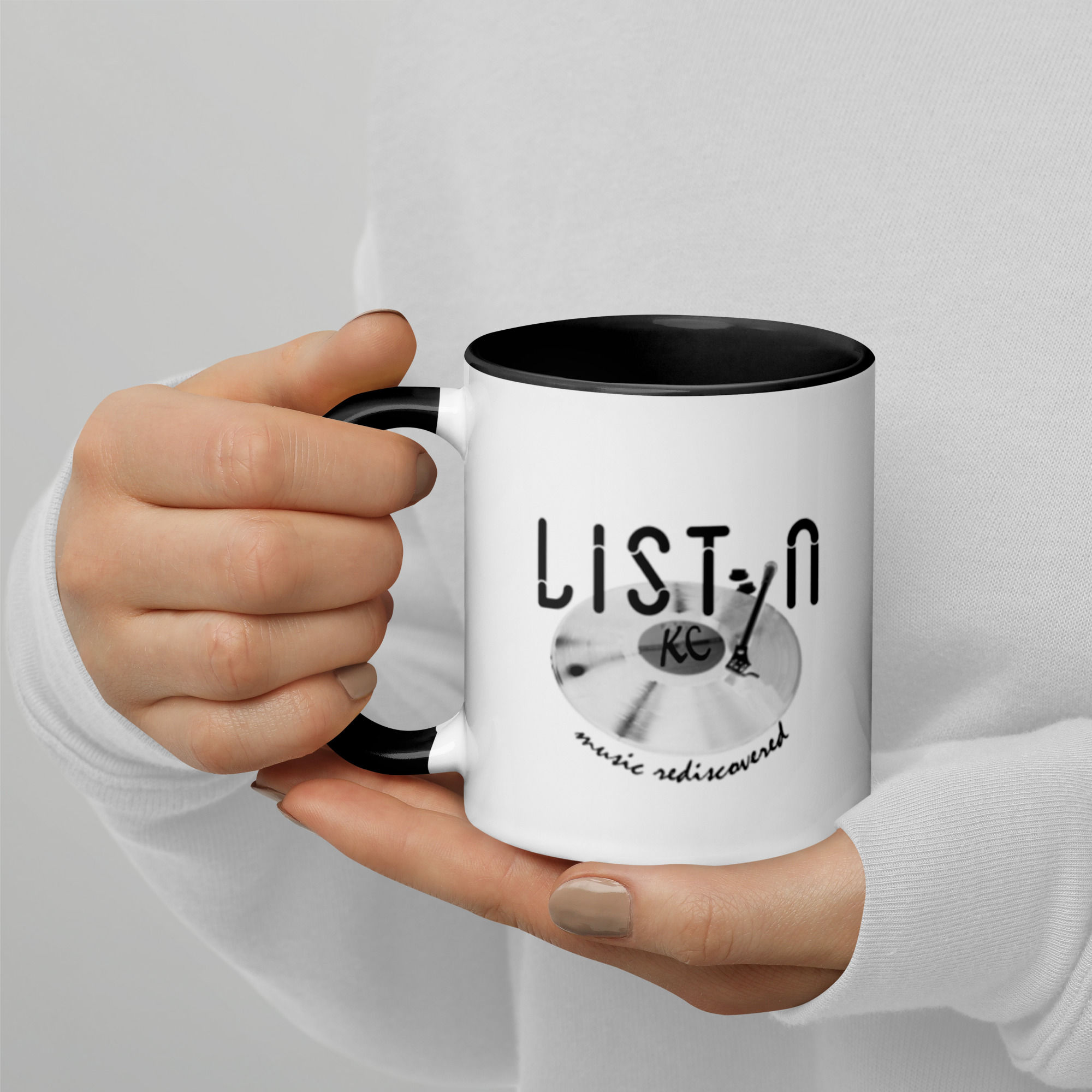 Woman holding a coffee mug with the text "LISTEN" and "music redefined"