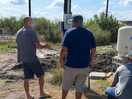 Homeowner discusses signs of a bad pressure tank with Texas Southern Drilling staff in Smithville, Texas, Bastrop County.