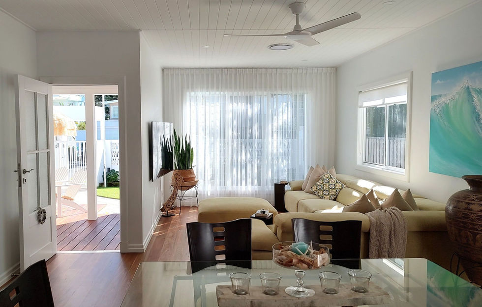 Open-plan living and dining area in a Mermaid Beach renovation connecting seamlessly to a front outdoor deck