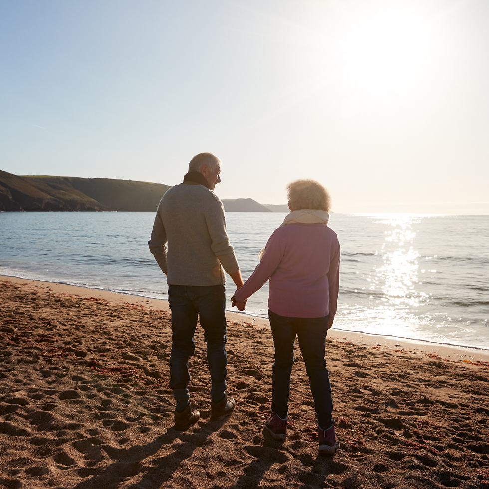 two people holding hands by the beach