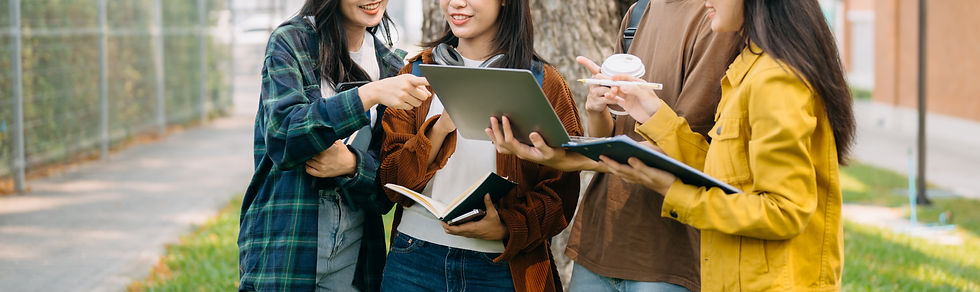 Group of young adults meeting outside with their computers, discussing a project.