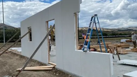 The first completed wall is in place, laying the groundwork for the rest of the home's framework.