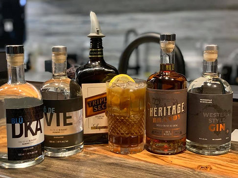 Strong cocktail with maple gin, multiple spirits, citrus and cola garnished with an orange slice