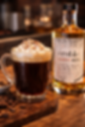 Hot coffee with acerum topped with whipped cream and chocolate