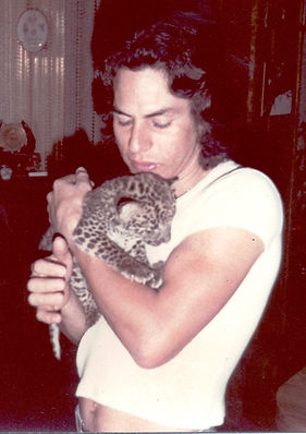 Young man holding leopard cub