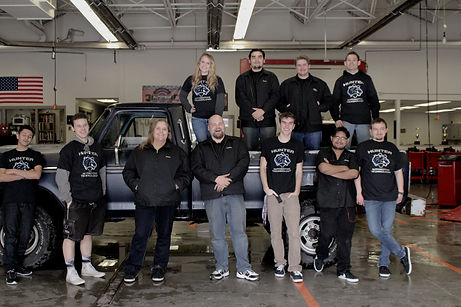 Tyler Perkins with the gearheads automotive students in their shop at Hunter High school