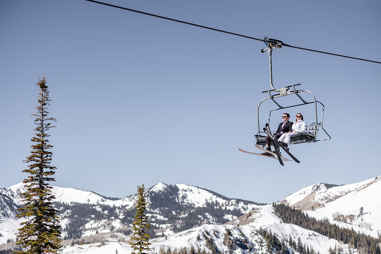 Bride and groom skiing together at Deer Valley during their winter wedding in Park City, Utah.