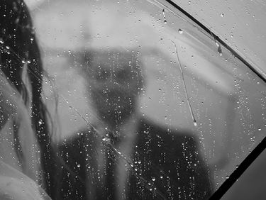 Rainy Elopement couple under umbrellas