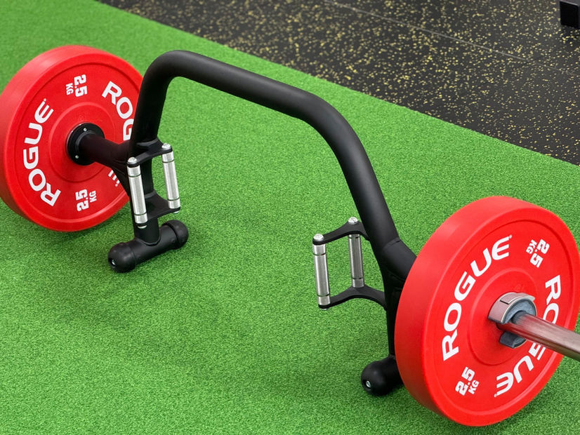 草皮區訓練情境,前景槓片與器材,後方為訓練架