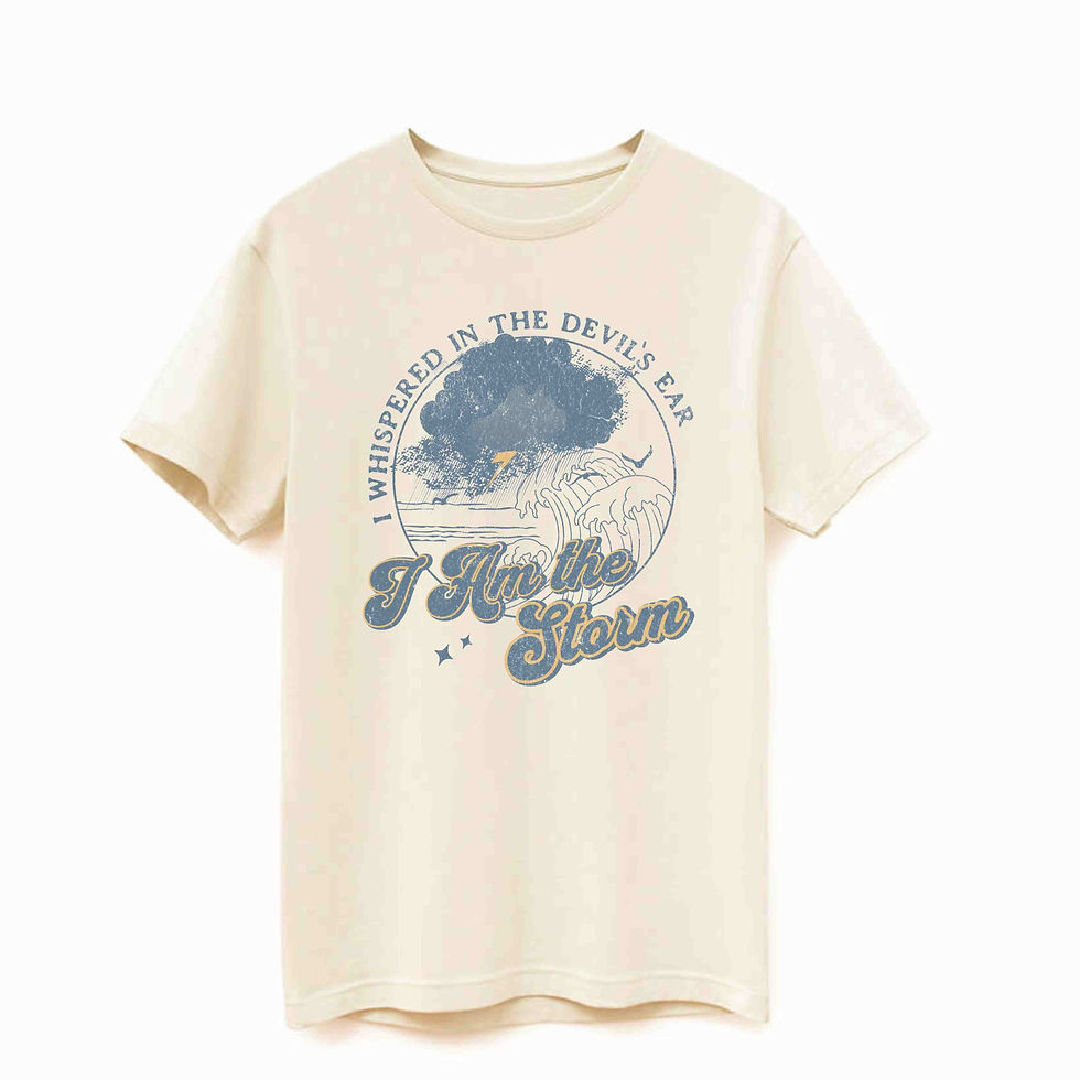 an ivory t-shirt with the picture of a storm over the sea with the words "I whispered in the devil's ear I AM the Storm".