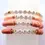 Thumbnail: hues of pinks polymer disk beads, with white round beads with gold lettering "Faith" "Joyful" "Love"