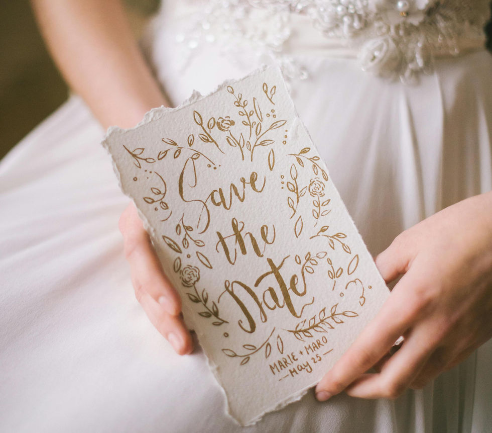 Elegant wedding save the date card with gold foil accents and floral design.