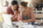 Man and woman looking at a laptop screen, planning a trip