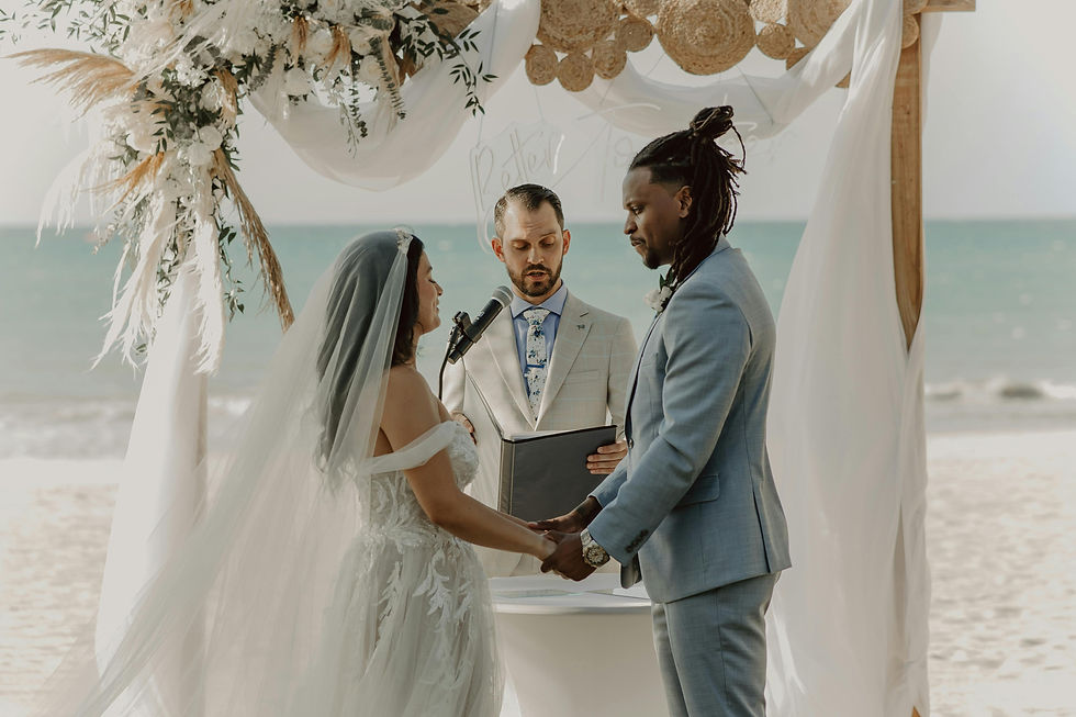A romantic moment on the sandy beach, as the bride and groom exchange heartfelt vows.