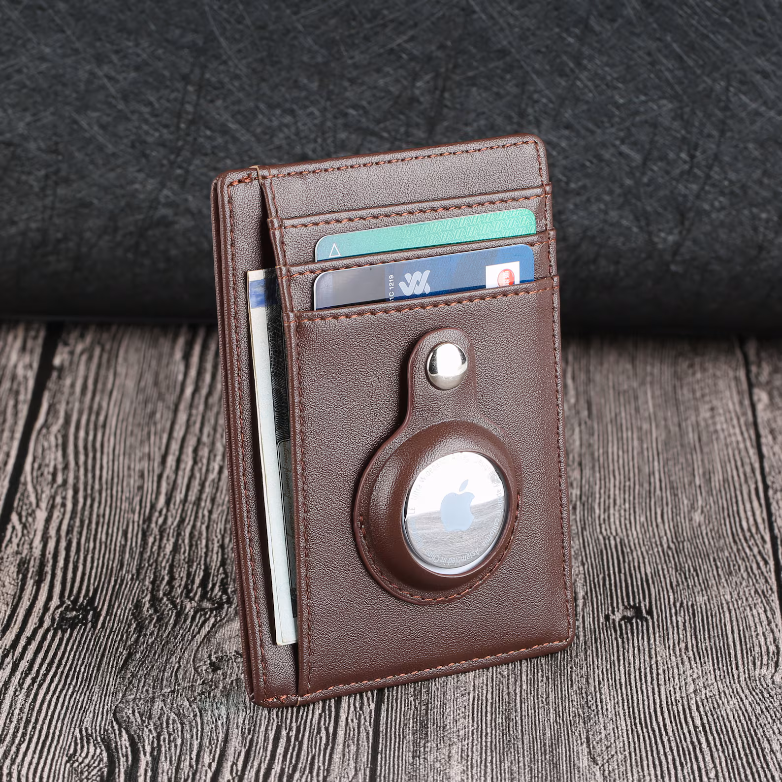 Apple AirTag in brown leather wallet with cards.