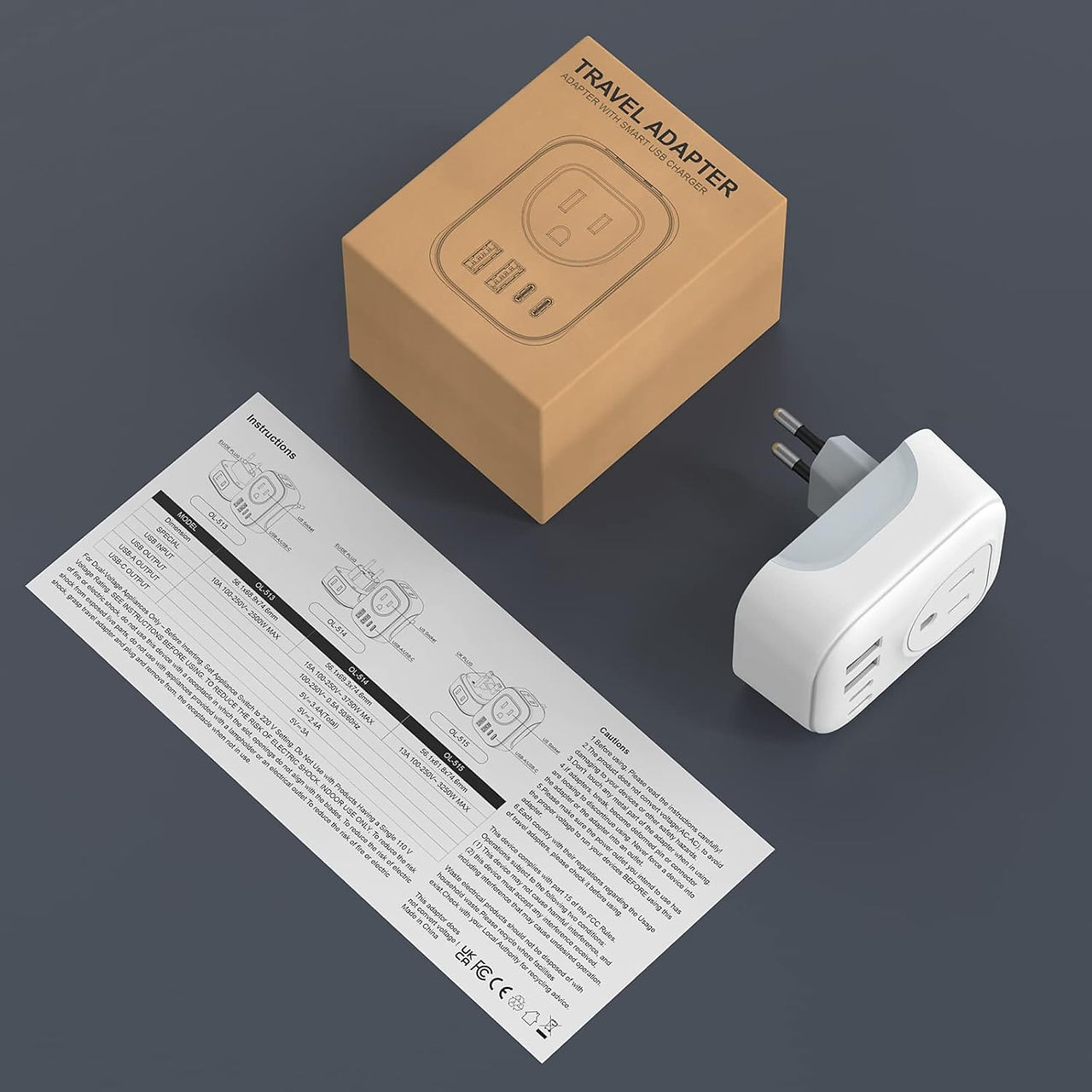 White travel adapter next to instruction manual and brown packaging box.