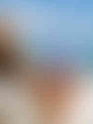 Person using waterproof phone pouch on the beach with clear touch screen access.