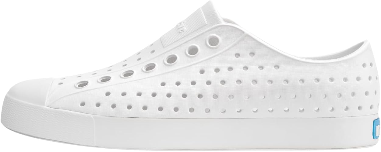 Side view of a white slip-on shoe with ventilation holes throughout the upper and a solid white sole.