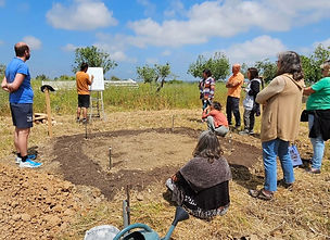 Participants gather around a newly prepared Mini Food Forest plot during a hands-on agroforestry workshop in Portugal
