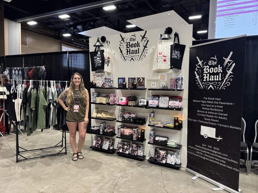 The Book Haul booth set up at a book event with merch and shelves
