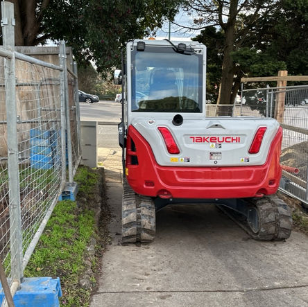 Small red and white excavator on a construction site