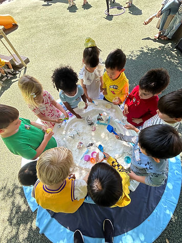 Diverse children scooping, pouring and playing at the Frozen activity table at Los Altos Christian School