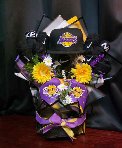 Custom gift baskets for a sports fan with yellow and purple flowers and hat.