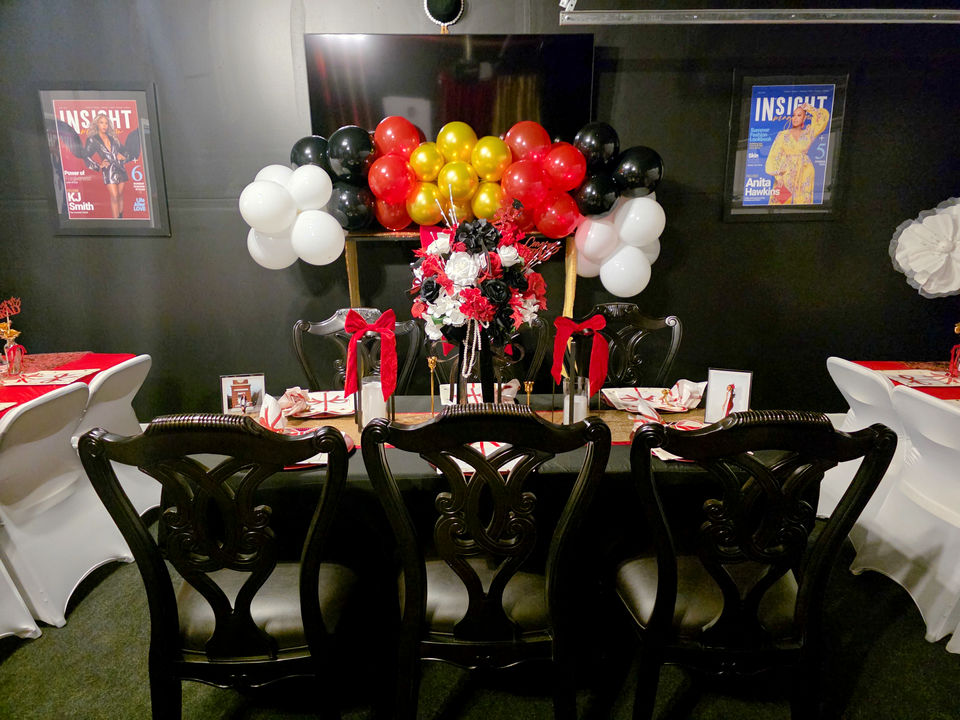 Special graduation decor in Gastonia with red, black, and gold balloons on a table.