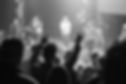 People with raised arms in praise during worship services.