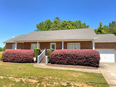Ranch-style brick Hope House for women with big front porch and flowering bushes