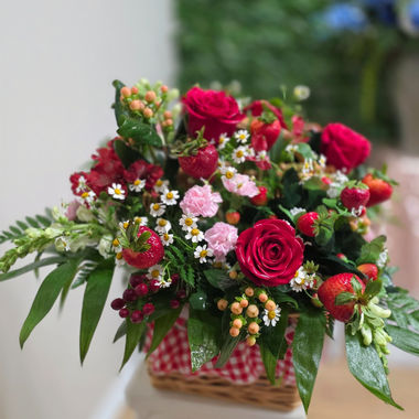 Custom designed flower basket with strawberries, red roses and pink flowers.
