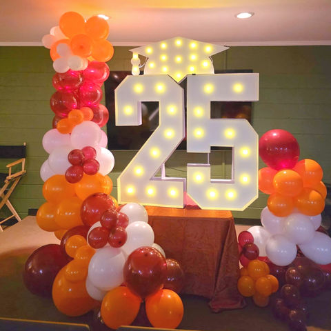 Graduation event decor in Gastonia with orange and red balloons.