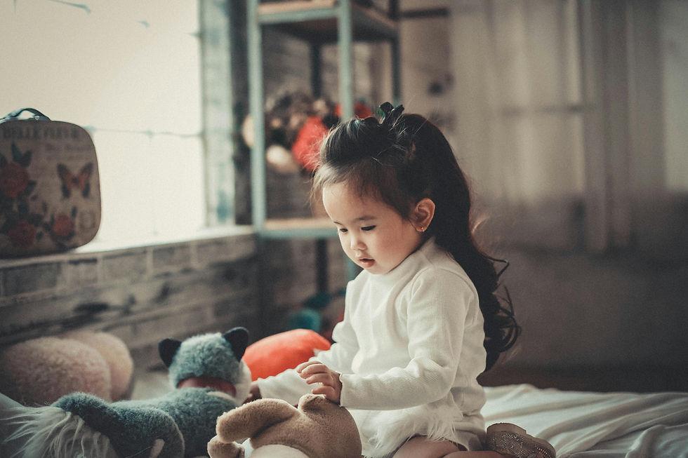 female child playing with toys whilst sitting down