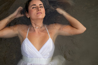 Woman laying in water with eyes closed.