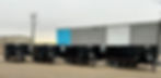Line of black enclosed trailers for MVB3X barrier transport, parked in an industrial lot