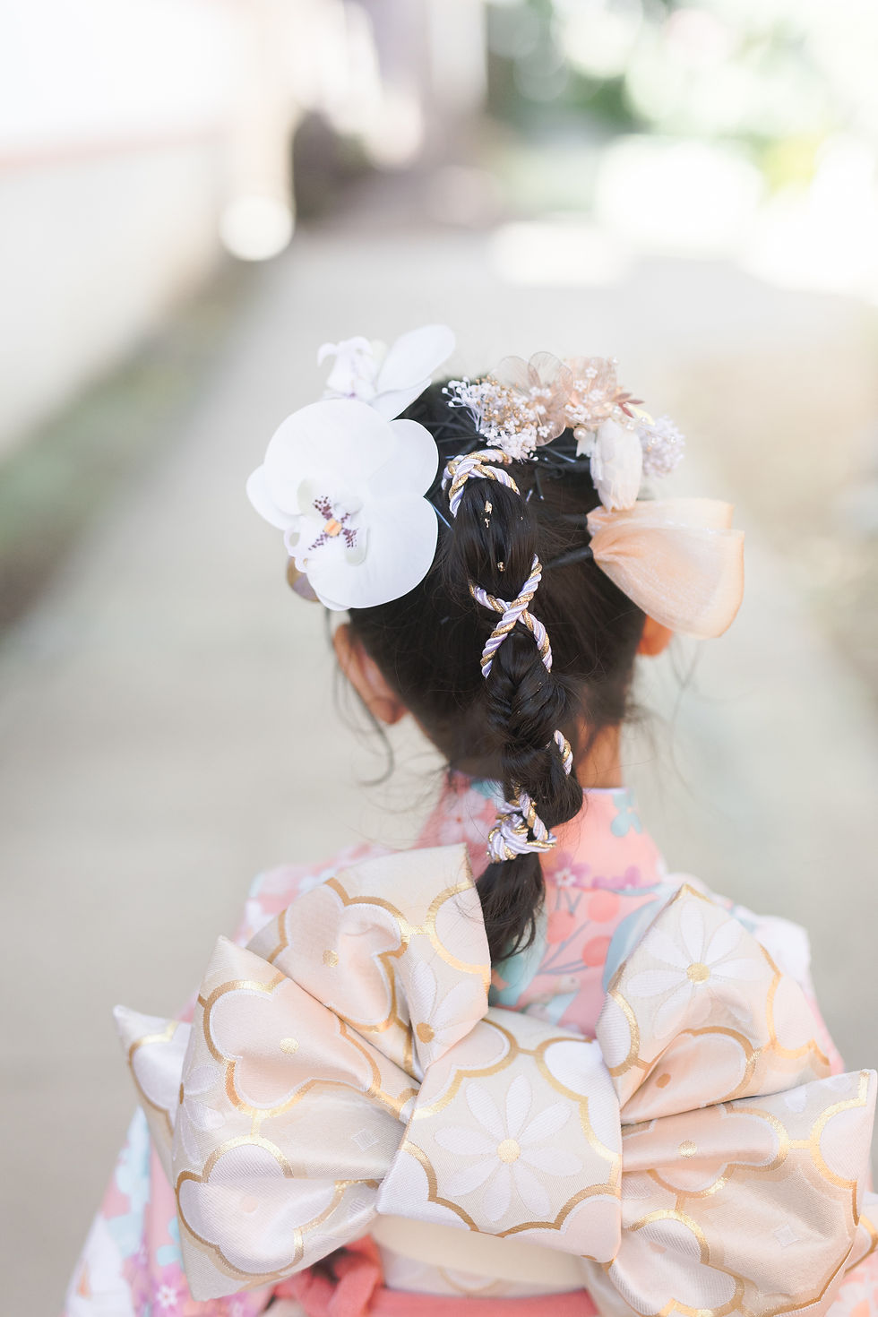 七五三の女の子の花の髪飾りと帯の後ろ姿
