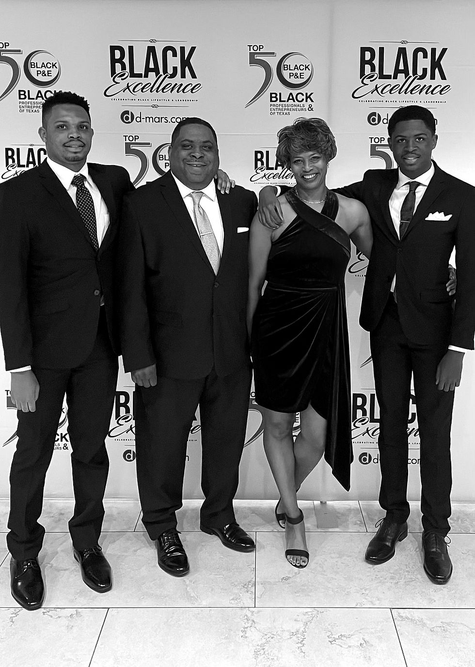 Four people in formal wear at a BLACK Excellence event