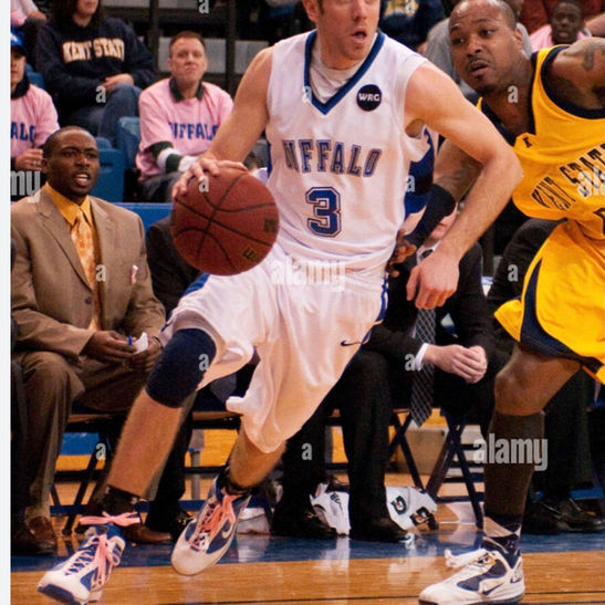 Basketball player in a white Buffaloes jersey dribbling